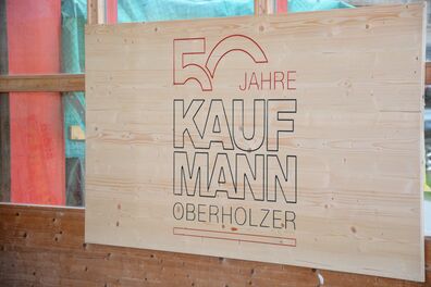Kaufmann Oberholzer - Jubiläumslogo auf Holz